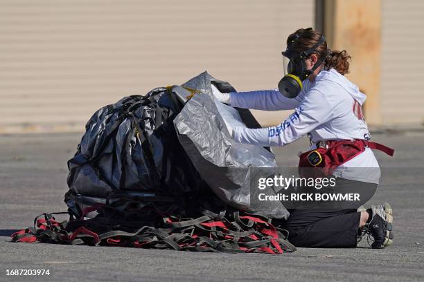 Recovery team member examines a space capsule carrying NASA's first asteroid samples on September 24, 2023 to a temporary clean room at Dugway...