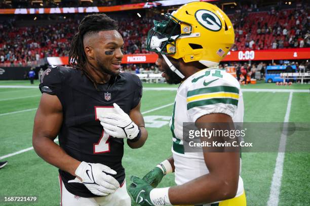 Bijan Robinson of the Atlanta Falcons and Emanuel Wilson of the Green Bay Packers embrace after the game at Mercedes-Benz Stadium on September 17,...