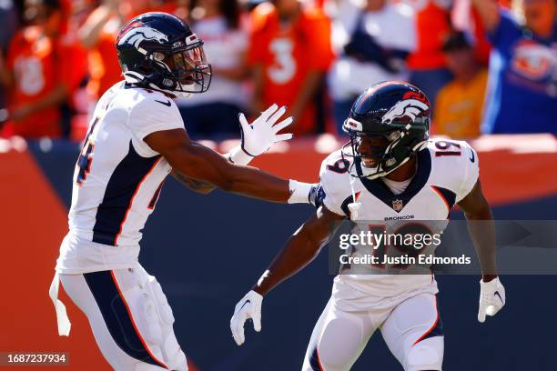 Courtland Sutton of the Denver Broncos celebrates with Marvin Mims Jr. #19 of the Denver Broncos after Mims' receiving touchdown during the first...