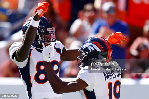 Brandon Johnson of the Denver Broncos celebrates with Marvin Mims Jr. #19 of the Denver Broncos after Mims' receiving touchdown during the first...