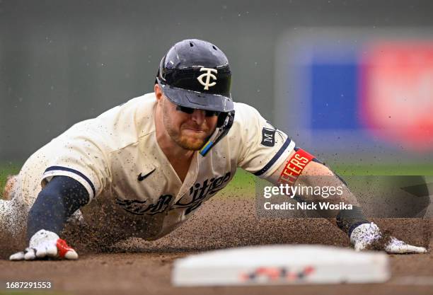 Kyle Farmer of the Minnesota Twins slides safely into third base on an RBI triple against the Los Angeles Angels during the sixth inning at Target...