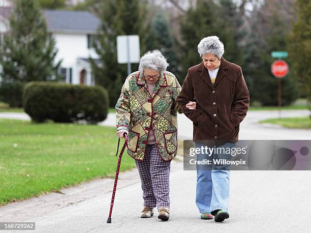 daughter walking with mother using cane - grandma cane bildbanksfoton och bilder