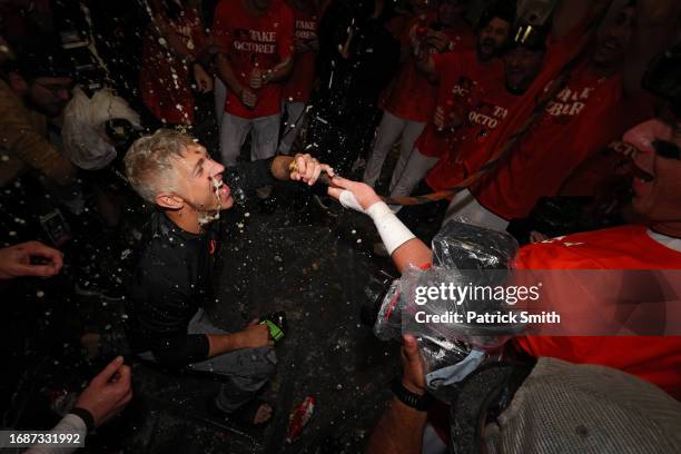 Executive Vice President and General Manager Mike Elias of the Baltimore Orioles drinks from the 'Homer Hose' as his team celebrates in the clubhouse...