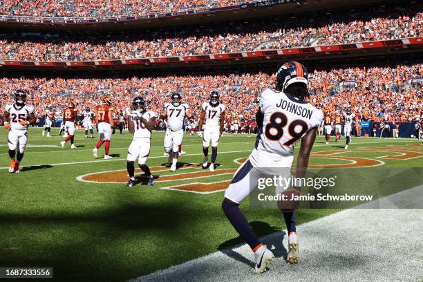 Brandon Johnson of the Denver Broncos celebrates after scoring a touchdown during the second quarter against the Washington Commanders at Empower...