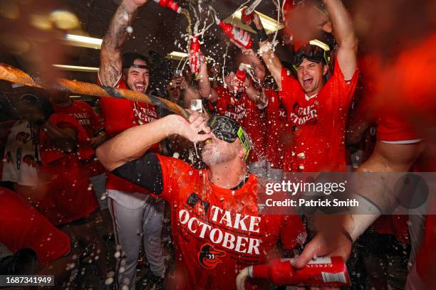 Manager Brandon Hyde of the Baltimore Orioles drinks from the 'Homer Hose' as his team celebrates in the clubhouse after the Baltimore Orioles...