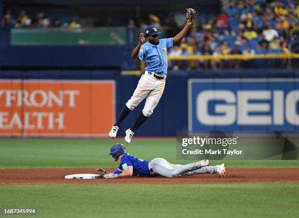 Tampa Bay Rays infielder Osleivis Basabe leaps to catch the throw as Toronto Blue Jays third baseman Matt Chapman steals second base during the...
