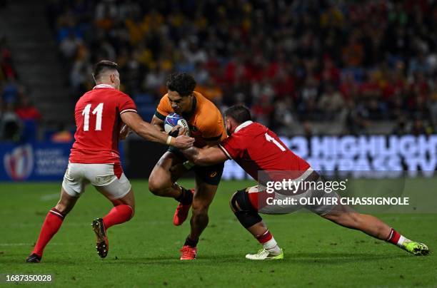 Australia's centre Jordan Petaia is tackled by Wales' left wing Josh Adams and Wales' loosehead prop Gareth Thomas during the France 2023 Rugby World...