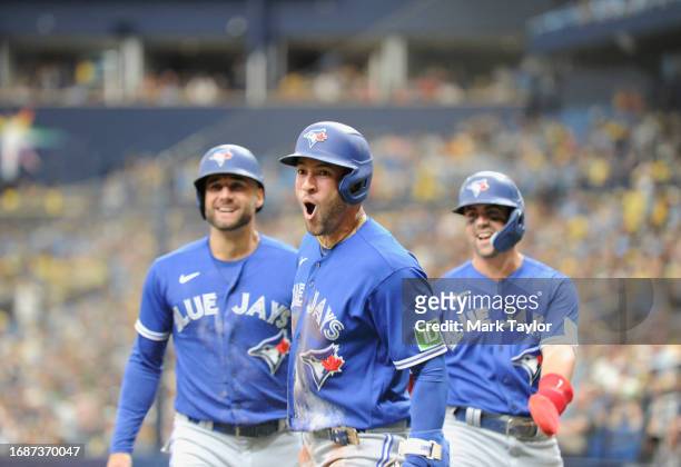 Toronto Blue Jays outfielder George Springer, center, celebrates hitting a second inning three-run inside the park home run against the Tampa Bay...