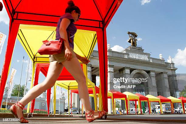 Girl walks past the main entrance to the VVTs in Moscow, on May 14, 2013. The temperatures in the Russian capital reached today to 26 C . AFP PHOTO /...