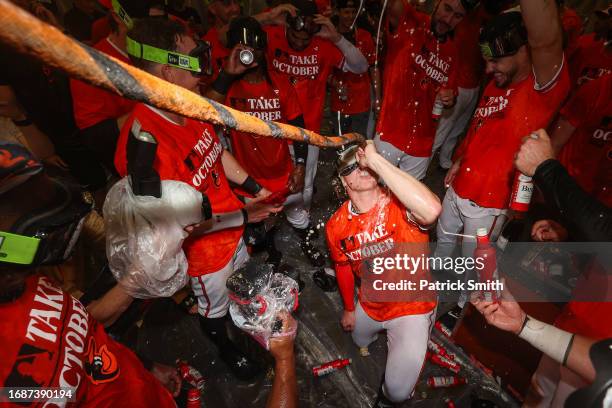 Heston Kjerstad of the Baltimore Orioles drinks from the 'Homer Hose' as he and teammates celebrate in the clubhouse after the Baltimore Orioles...