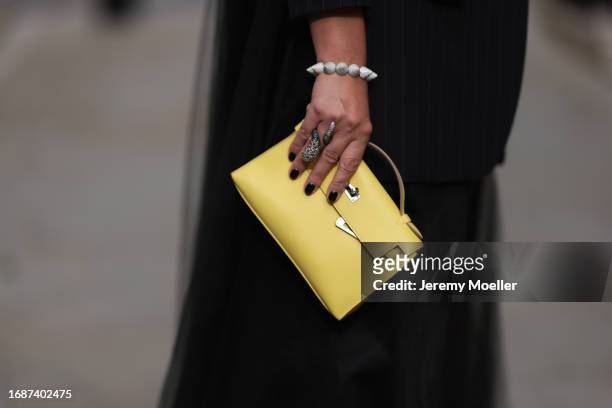 Corina Mihaila Larpin is seen wearing bracelet and ring from Stéfère, a black pinstripe blazer with long tulle back from Monse and the Kelly bag from...