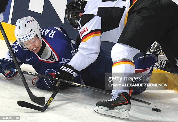 French forward Damien Raux vies for the puck with Germany's forward Marcel Goc during the preliminary round match France vs Germany of the IIHF...