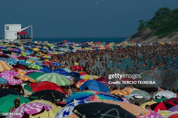 Sunbathers enjoy at Macumba beach, in the west zone of Rio de Janeiro, on September 24 during a heat wave which registered 39.9 degrees.