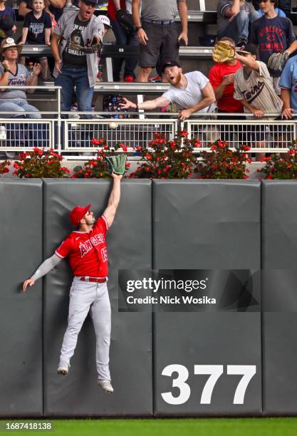 Randal Grichuk of the Los Angeles Angels unsuccessfully attempts to rob a home run from Ryan Jeffers of the Minnesota Twins during the seventh inning...