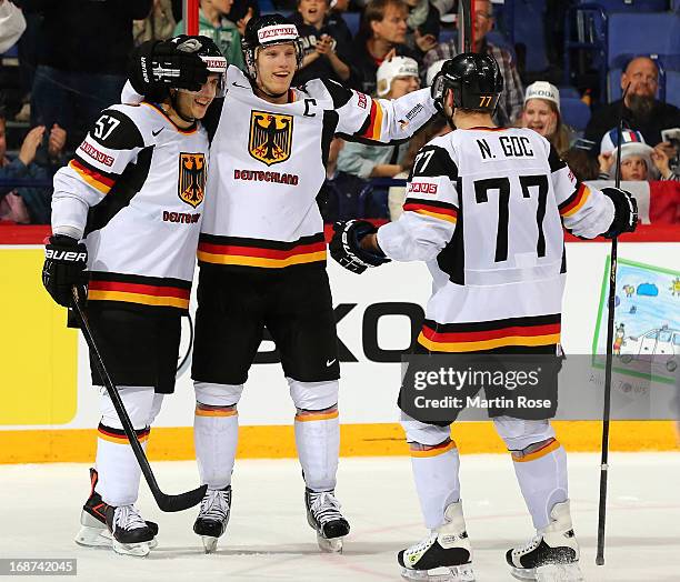 Marcel Goc, Christian Ehrhoff and Nicolai Goc of Germany celebrate after the IIHF World Championship group H match between France and Germany at...
