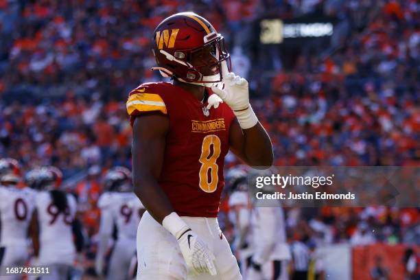 Brian Robinson Jr. #8 of the Washington Commanders celebrates after scoring a rushing touchdown during the fourth quarter against the Denver Broncos...