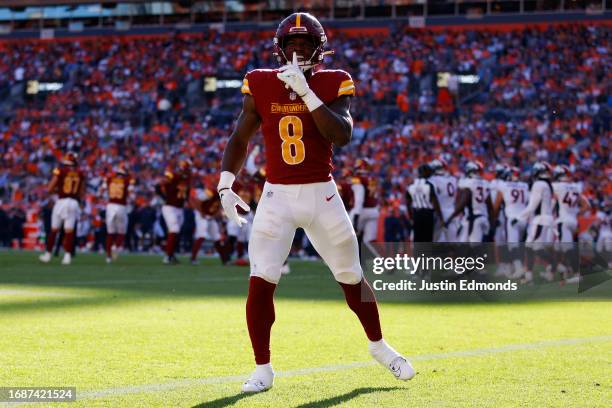 Brian Robinson Jr. #8 of the Washington Commanders celebrates after scoring a rushing touchdown during the fourth quarter against the Denver Broncos...