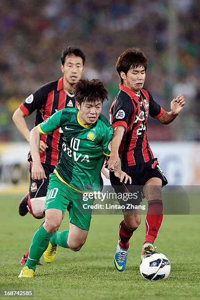 Xizhe Zhang of Beijing Guoan challenges Yun Illok and Han Tae-You of Seoul FC during the AFC Champions League Round of 16 match between Beijing Guoan...