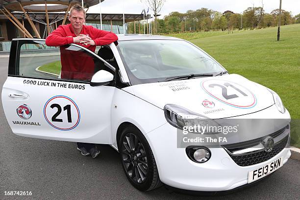 In this handout image provided by The FA, Stuart Pearce poses with a special Vauxhall Adam during the England Under 21 Squad Announcement for the...