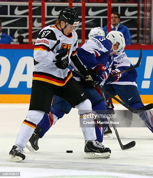 Vincent Bachet of France and Philip Gogulla of Germany battle for the puck during the IIHF World Championship group H match between France and...