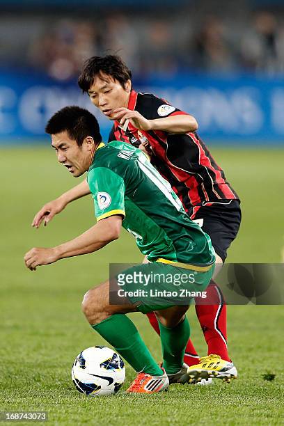 Xiaolong Wang of Beijing Guoan challenges Dejan Damjanovic of Seoul FC during the AFC Champions League Round of 16 match between Beijing Guoan and...