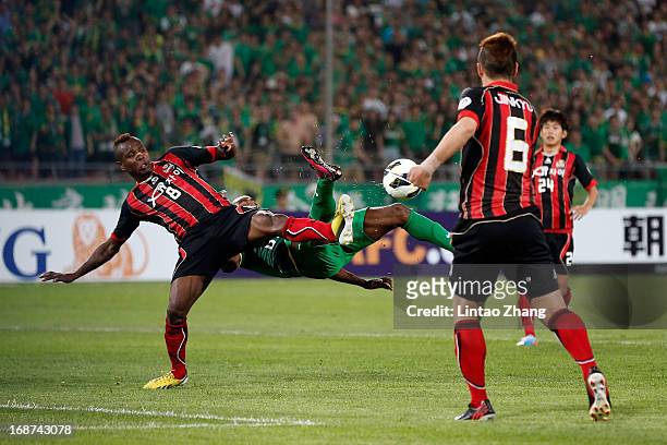 Adilson of Seoul FC challenges Joffre Guerron of Beijing Guoan during the AFC Champions League Round of 16 match between Beijing Guoan and Seoul FC...