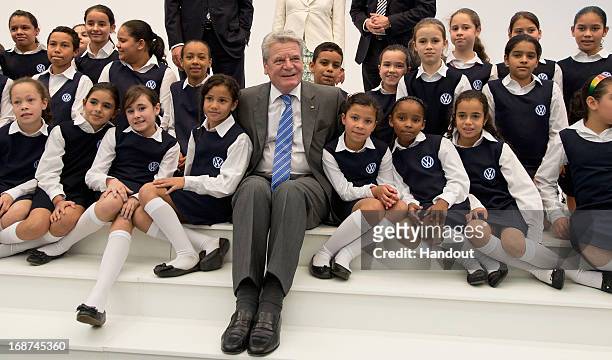 German President Joachim Gauck poses with the children's choir group "Coral da Gente", who come from a Sao Paolo slum, while touring the Volkwagen...