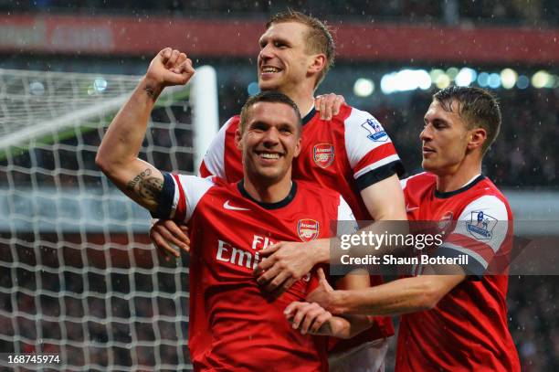 Lukas Podolski of Arsenal celebrates with team mate Per Mertesacker and Aaron Ramsey after scoring during the Barclays Premier League match between...