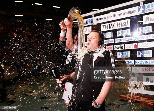 Head coach Alfred Gislason of Kiel is drenched in beer by Filip Jicha the DKB Handball Bundesliga match between THW Kiel and Fuechse Berlin at...