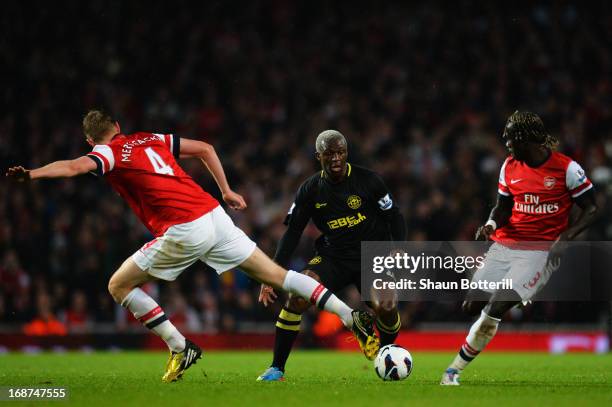 Per Mertesacker and Barcary Sagna of Arsenal tackle Arouna Kone of Wigan Athletic during the Barclays Premier League match between Arsenal and Wigan...