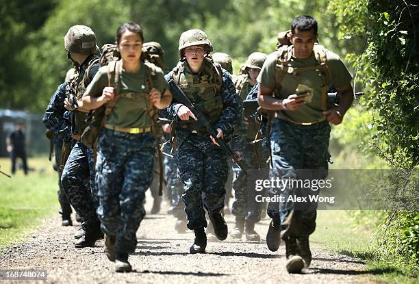 Members of the United States Naval Academy freshman class take part in a ruck run as they participate in the annual Sea Trials May 14, 2013 in...