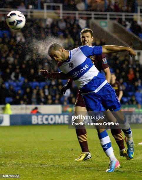 Adrian Mariappa of Reading heads the ball clear as the rain pours during the Barclays Premier League match between Reading and Manchester City at the...