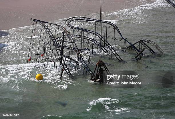 Crane demolishes the JetStar roller coaster more than 6 months after it fell into the ocean during Superstorm Sandy on May 14, 2013 in Seaside...