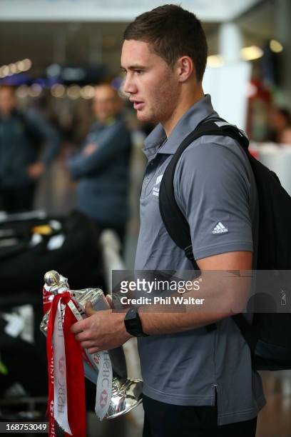 Gillies Kaka of the New Zealand All Blacks Sevens team arrives at Auckland International Airport with the HSBC Sevens World Series Trophy on May 15,...