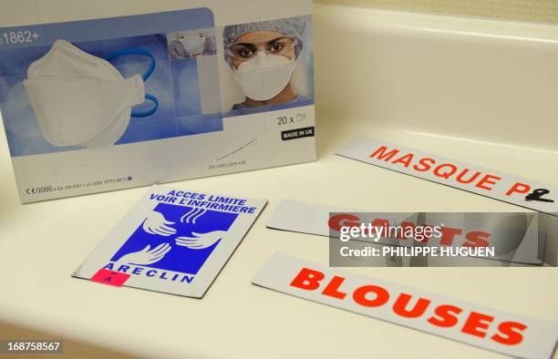 Picture taken on May 14, 2013 shows a box of medical masks and signs reading "masks", "gloves" and "blouse'' at the infectious diseases unit at the...