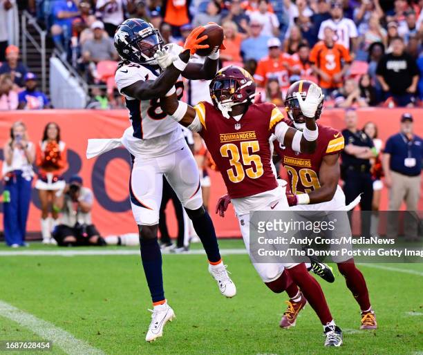 Denver Broncos wide receiver Brandon Johnson reaches out and catches a Hail Mary pass thrown by QB Russell Wilson for a touchdown against Washington...