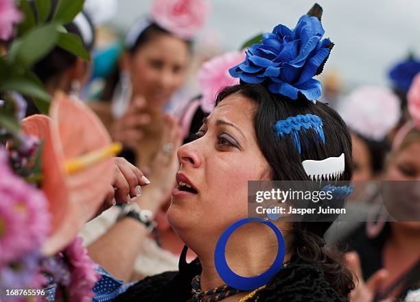 Pilgrims of the Chipiona hermandades stands emotional by the side of her carriage onboard a vessel crossing the Guadalquivir river during her journey...