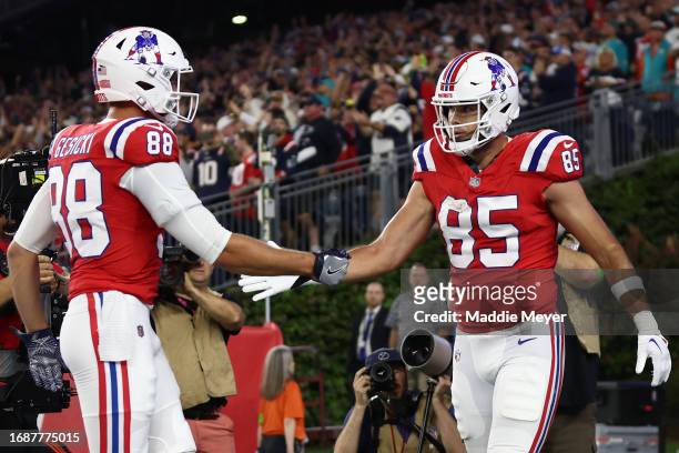 Hunter Henry of the New England Patriots celebrates his touchdown catch with Mike Gesicki during the fourth quarter against the Miami Dolphins at...