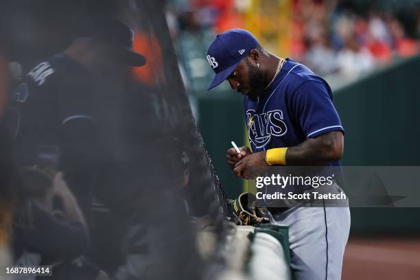 Randy Arozarena of the Tampa Bay Rays signs autographs for fans before the game against the Baltimore Orioles at Oriole Park at Camden Yards on...