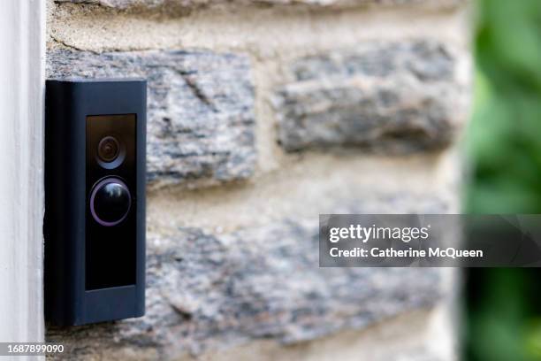 video camera smart doorbell on residential stone wall background - doorbell stock-fotos und bilder