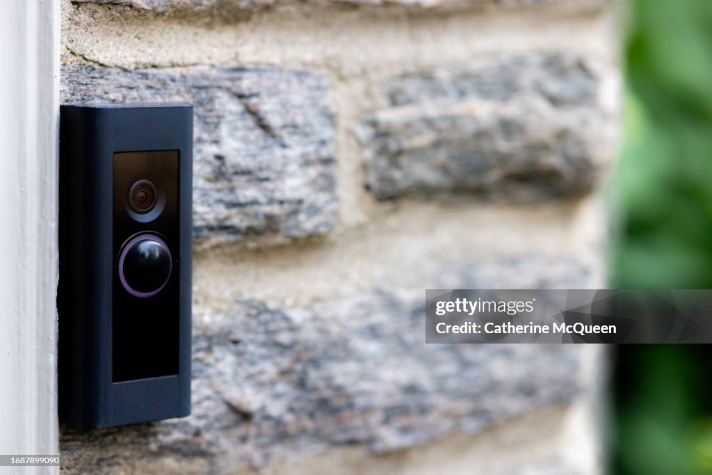 Video camera smart doorbell on residential stone wall background