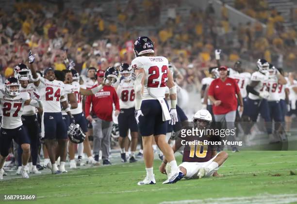 Drew Pyne of the Arizona State Sun Devils is knocked down by Steven Comstock of the Fresno State Bulldogs on a fourth down passing attempt during the...