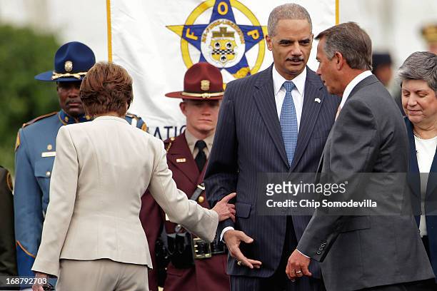 Attorney General Eric Holder extends a hand to Speaker of the House John Boehner as House Minority Leader Nancy Pelosi touches his sleeve before the...