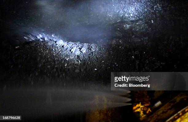 Coal runs along a conveyor belt after being scraped off the wall by a shearer during longwall mining operations at the Consol Energy Bailey Mine in...