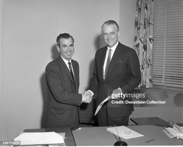 Bobby Mellen shakes hands with actor Douglas Fairbanks, Jr. At a Cash Box Magazine photo shoot on March 27, 1958 in New York, New York.