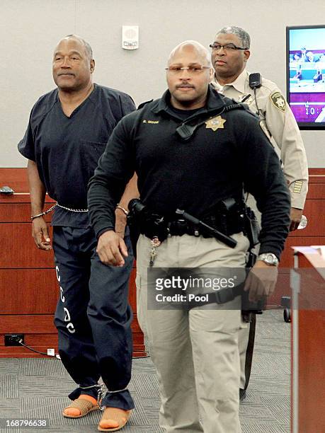 Simpson is escorted by Ric Moon, Clark County Marshal and Las Vegas Police correctional officer George Gafford during a break in an evidentiary...