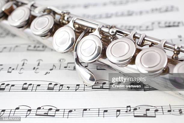 flute closeup on music - flautist stock pictures, royalty-free photos & images