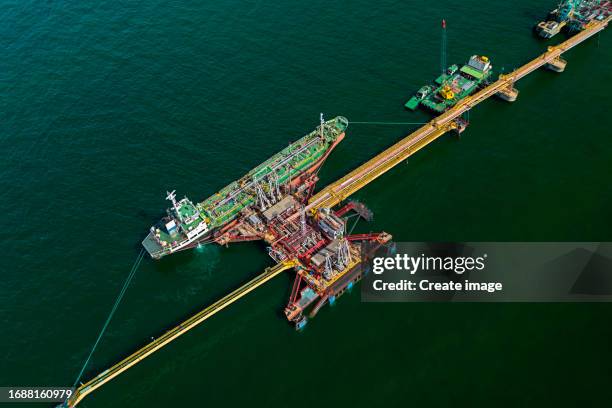 aerial view oil ship tanker load or unload oil at loading dock for transportation oil from refinery on the sea. - oil refinery stock pictures, royalty-free photos & images