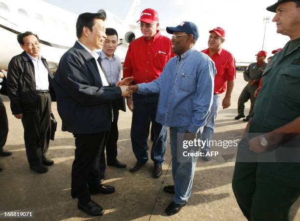 China's Vice President Li Yuanchao , accompanied by PDVSA Venezuela's state-owned oil company president Rafael Ramirez , shakes hands with the...
