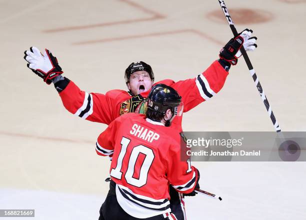 Marian Hossa of the Chicago Blackhawks celebrates a first period goal with teammate Patrick Sharp against the Detroit Red Wings in Game One of the...